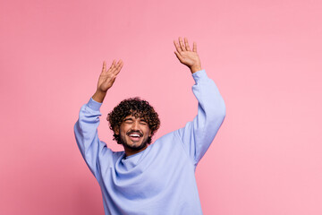 Photo of glad nice funny man wear blue stylish clothes dance with raised hands good mood chill isolated on pink color background