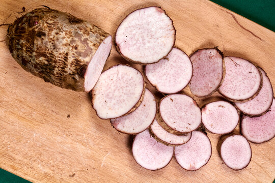 closeup of taro root vegetable, eddo malanga, green background