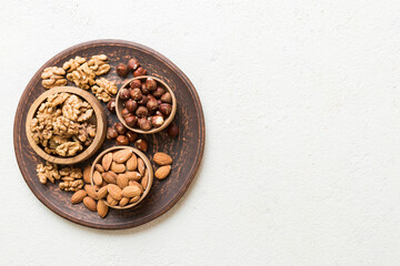 Obraz na płótnie Canvas mixed nuts in wooden bowl. Mix of various nuts on colored background. pistachios, cashews, walnuts, hazelnuts, peanuts and brazil nuts