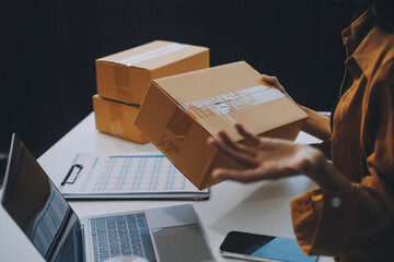businesswoman start small business and successful SME entrepreneurs asian woman hoding boxs works from home delivering parcels online. SME delivery concept and packaging - obrazy, fototapety, plakaty