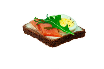 sandwich with red fish, arugula, boiled egg and cucumber. a slice of bread with fish and greens on a white background