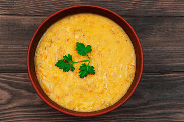 pea soup with a sprig of parsley in a clay plate