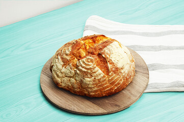 baked Italian bread on a light wooden table. ciabatta on a white towel on a wooden background	