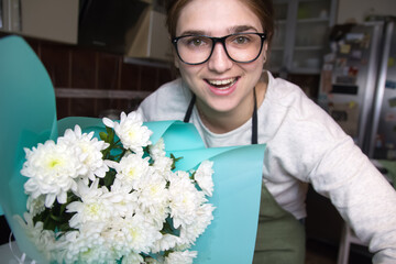 Florist woman smiling holding bouquet with white daisies. This s - Powered by Adobe