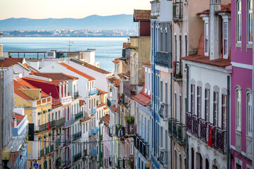 Dramatic view of colorful historic buildings in Lisbon, Portugal with the Tagus River in the background