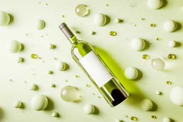 White wine Bottle Mockup with Blank Label. Presentation of glass bottle with natural white wine with empty white label lying on tender mint background with spherical shapes. Template