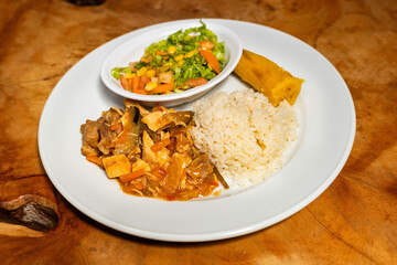 Stewed beef goulash with banana, white rice and vegetable salad
