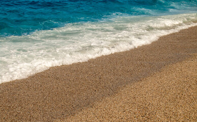 Hermosa playa con olas y guijarros, Carboneras, España. Suave ola rompiendo contra la playa en un soleado día de verano. Playa de Los Muertos en Almería.