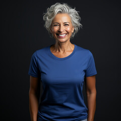 Smiling old woman wearing blue T-Shirt Mockup on black studio background