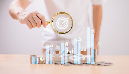 Fototapeta premium Target Goal challenge concept. Start 2024 plan Money saving, Retirement fund, Pension, Investment Financial. Businessman use magnifying glass, seo marketing. Business survival earning income profit