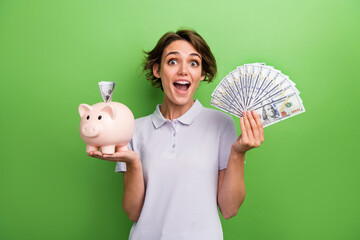 Photo of overjoyed girl hold piggy bank cash dollars rejoice wealth luxury future life isolated on...