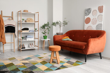 Interior of modern dressing room with brown sofa and ottoman