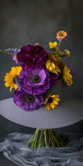the hat and the vibrant hues of purple ranunculus and yellow gerberas adorning its brim, highlighting the beauty of nature's palette in a stylish and sophisticated display.