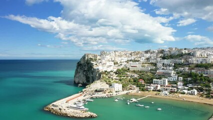 The city center, the port and the beach of Peschici in Europe, In Italy, in Puglia, towards Foggia, in summer, on a sunny day.