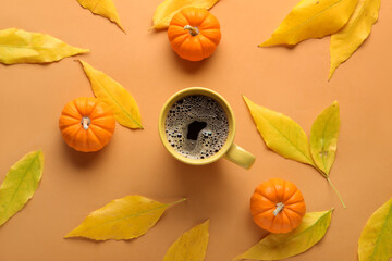 Beautiful composition with cup of aromatic coffee, pumpkins and autumn leaves on color background