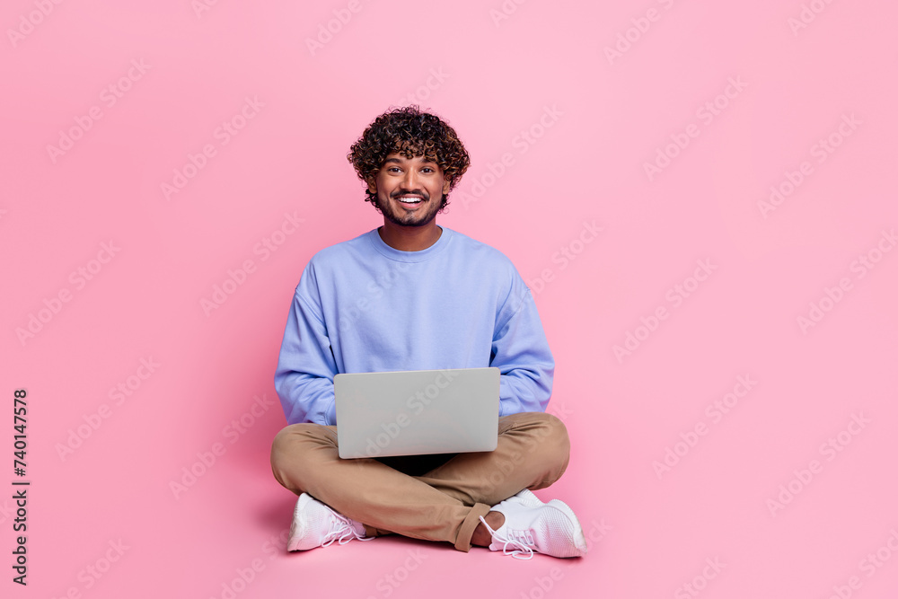 Poster Full body photo of attractive young man sit floor work netbook smm manager wear trendy blue clothes isolated on pink color background