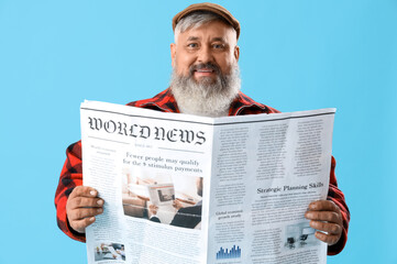 Mature man with newspaper on blue background
