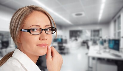 Headshot portrait of confident businesswoman on office background.