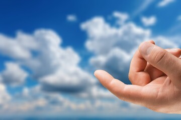 Human hand finger on nature sky background