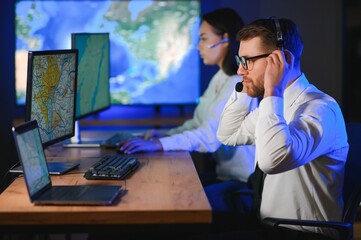 Center of dispatching maintenance. Portrait of cheerful woman and man working via headset...