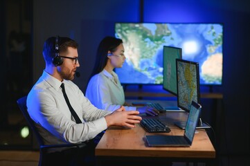 Male Data Scientist Works on Personal Computer Control and Monitoring Room. Map Surveillance of...