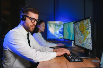 Center of dispatching maintenance. Portrait of cheerful woman and man working via headset...