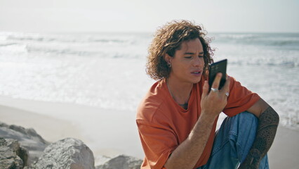 Tourist using telephone beach beautiful sunny day. Guy finishing phone call.