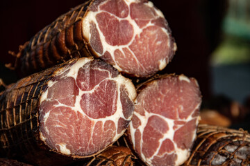 Delicious pieces of smoked meat exposed for sale in the market  presented for sale on a farmer's market in Kacarevo village, gastro bacon and dry meat products festival called Slaninijada (bacon fest)