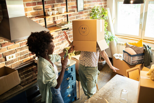 Lesbian couple having fun while moving into a new home with boxes