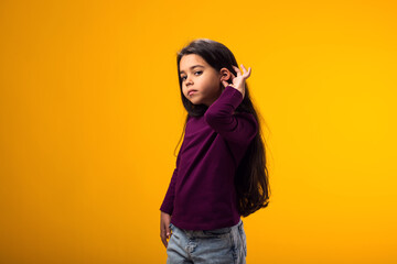 Kid girl eavesdropping, overhearing confidential secret conversation, keeping hand at his ear....