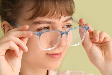 Young businesswoman in eyeglasses on green background, closeup. Glaucoma awareness month