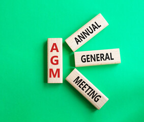 AGM - Annual general meeting symbol. Concept word AGM on wooden blocks. Beautiful green background. Business and AGM concept. Copy space.