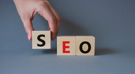 SEO - Search Engine Optimization symbol. Wooden blocks with words SEO. Businessman hand. Beautiful...