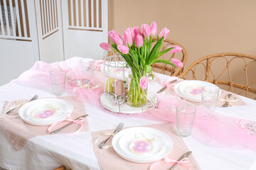 Dining table with setting and tulip flowers served for International Women's Day celebration