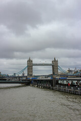 The Tower bridge in a cloudy day with the huge war ship infront of it, London, United Kingdom