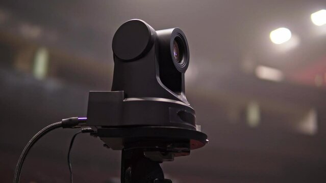  A robotic camera captures images at a concert, where bright lights and visual effects create a futuristic and exciting atmosphere concert concept button, television, production, video, broadcasting