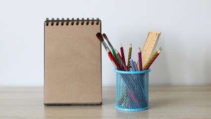 colored pencils and a notebook on the table, stationery. copy space. study, drawing and education...