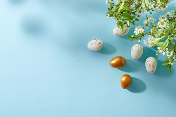 Holiday composition with spring flowers and easter eggs on a blue background. Happy easter flat lay...