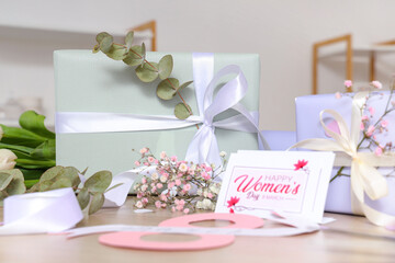 Beautiful gift boxes, flowers and greeting card for International Women's Day on wooden table