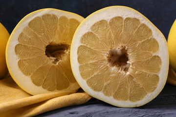 Tasty cut pomelo fruits with napkin on blue wooden table