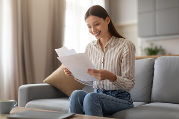Happy woman reading letters at home