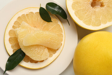 Tasty whole and cut pomelo fruits with pieces on white background