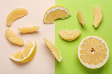 Tasty cut pomelo fruit with slices on colorful background