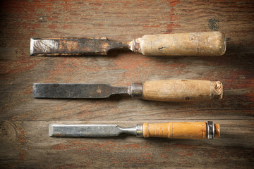 Three disused wood chisels on a wood table