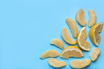 Sweet pomelo slices and pieces on blue background