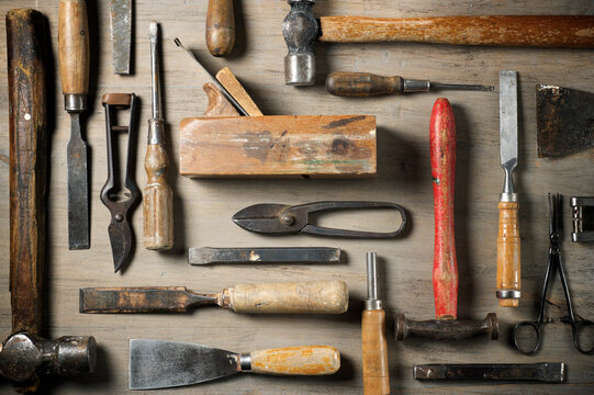 Old disused hand tools on a wooden table.