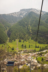 two rows of cable cars one going uphill while one going downhill. Cable Cars On An Alpine Mountainside. Cable car trip to viewpoints in the mountains. Tourists enjoy beautiful views.