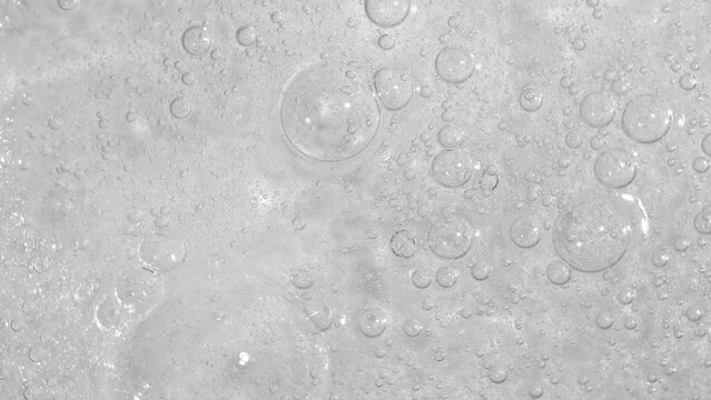 Texture of transparent cosmetic gel with bubbles, the texture of serum. Movement, rotation of sample of cosmetic skin care product