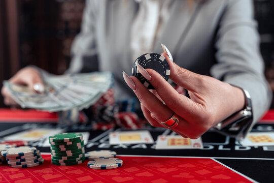 female player takes chips and raises in poker game at casino