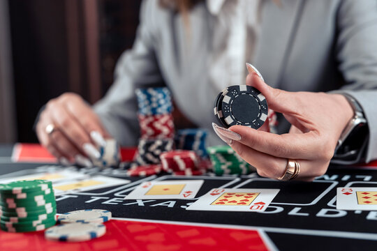 Excited business woman in suit playing poker in casino